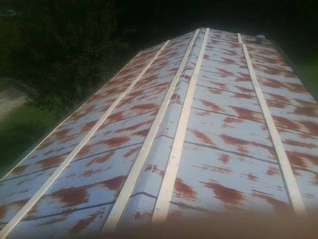 Rusted metal roof panels with new wood purlins before replacement — Storm Damage Roof Repair in Port Jefferson Station by Roofing Brothers